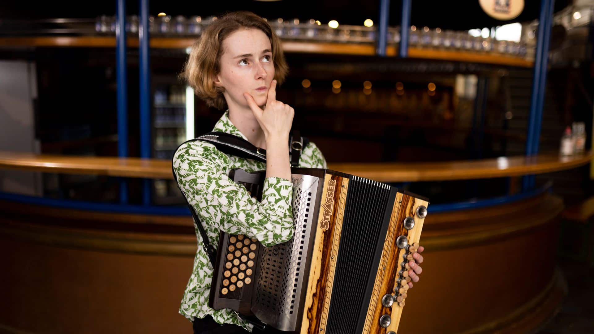 Celia schaut grübelnd und fragt sich warum Harmonikalernen ohne Harmonika üben nicht geht